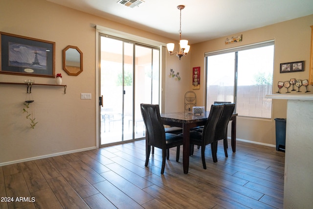 dining area with wood-type flooring and an inviting chandelier