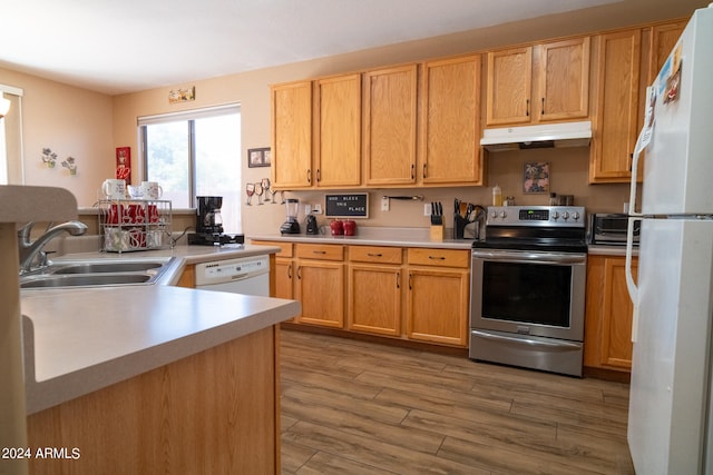 kitchen featuring sink, wood-type flooring, and white appliances