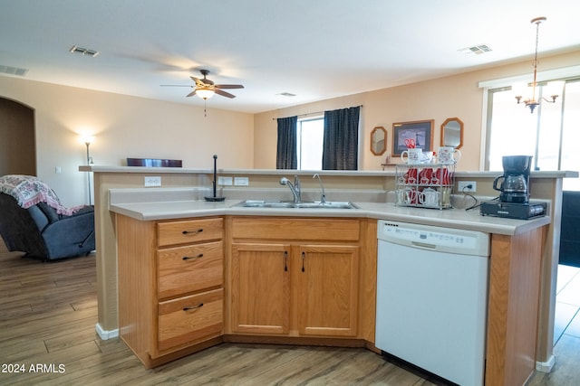 kitchen with sink, white dishwasher, hanging light fixtures, and light hardwood / wood-style flooring