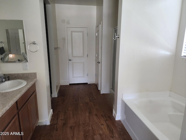7251 E Grouse Ct, San Tan Valley, AZ 85143 - full bath with baseboards, wood finished floors, a garden tub, and vanity