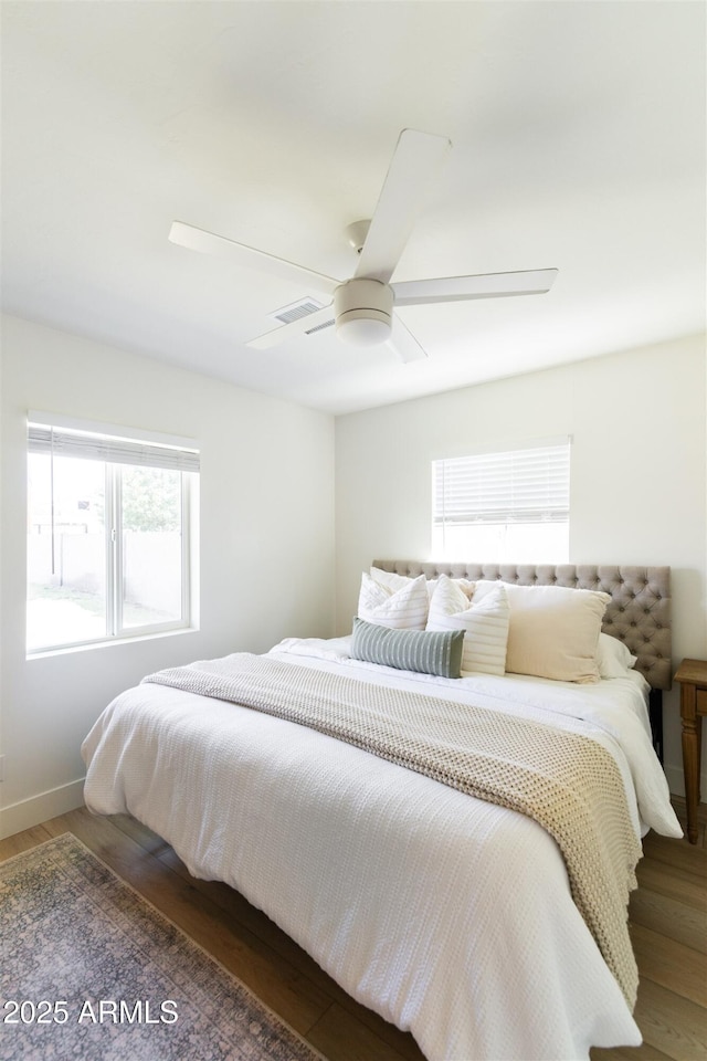 bedroom featuring wood finished floors, a ceiling fan, and baseboards