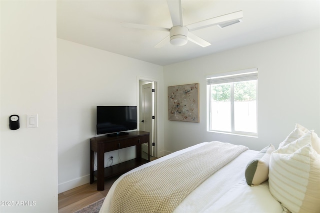 bedroom featuring wood finished floors, baseboards, and ceiling fan