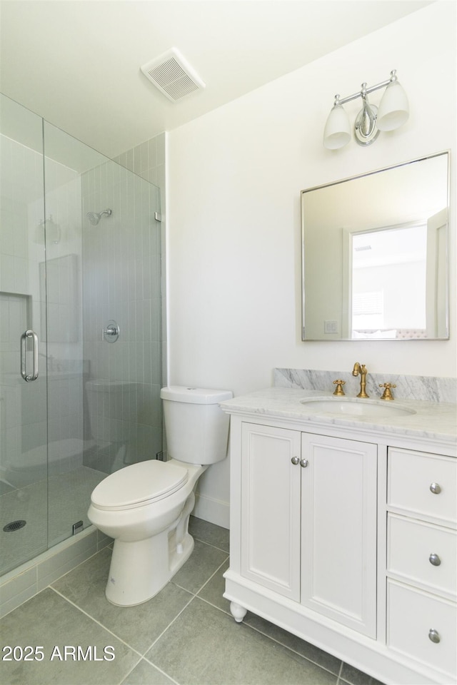 full bath featuring a shower stall, vanity, toilet, and tile patterned flooring