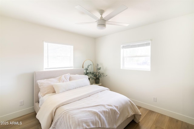 bedroom featuring baseboards, light wood-style flooring, and a ceiling fan