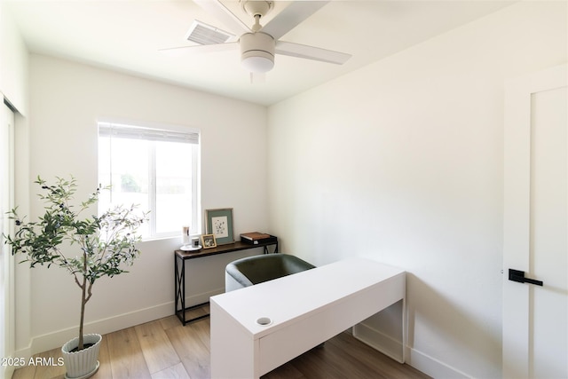 office space with baseboards, ceiling fan, and light wood-style floors