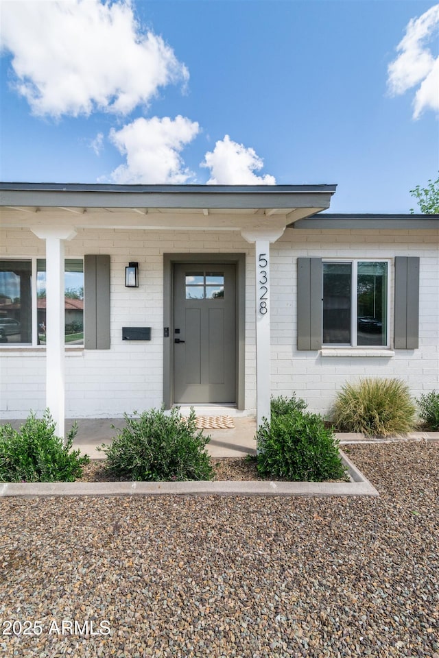 doorway to property with brick siding