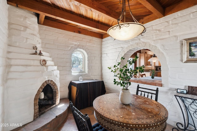 dining space with beamed ceiling, wood ceiling, and arched walkways