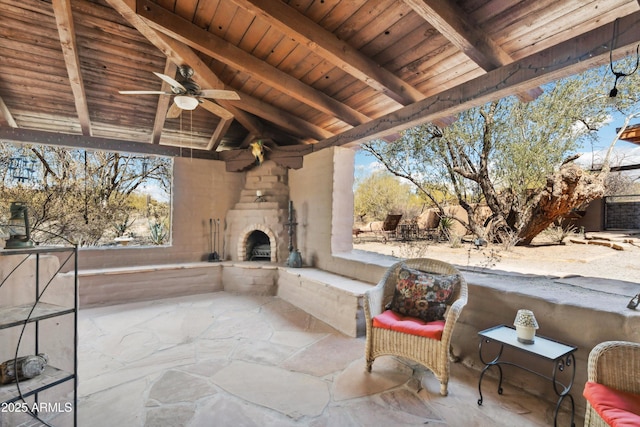 view of patio / terrace with ceiling fan and an outdoor stone fireplace