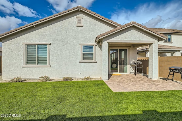 rear view of property with a yard and a patio area