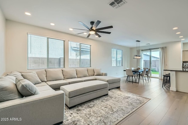 living room with light hardwood / wood-style flooring and ceiling fan