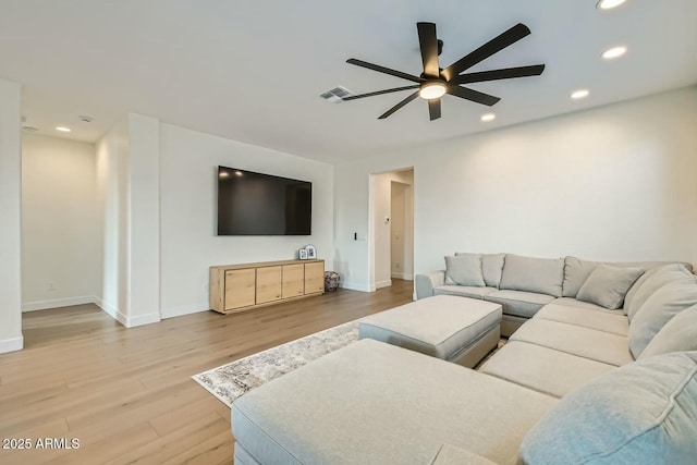 living room featuring ceiling fan and light wood-type flooring