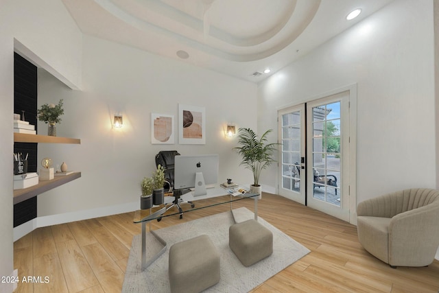 home office featuring light hardwood / wood-style flooring, french doors, and a high ceiling