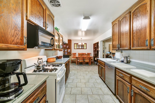 kitchen with a chandelier, white range with gas cooktop, dishwasher, a sink, and black microwave