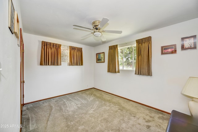 spare room featuring ceiling fan, carpet, and baseboards