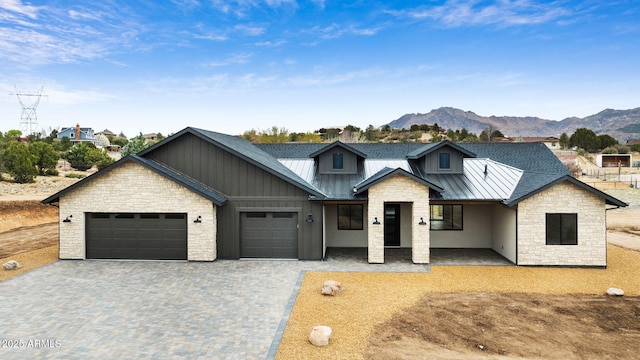 4613 W Stazenski Rd, Prescott, AZ 86305 - modern farmhouse with stone siding, metal roof, decorative driveway, an attached garage, and a standing seam roof