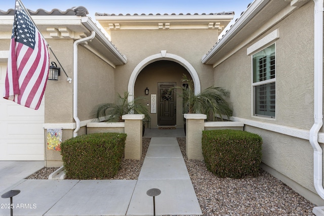 doorway to property with a tile roof and stucco siding