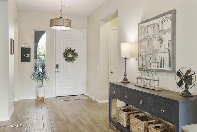 foyer featuring light wood-style flooring and baseboards