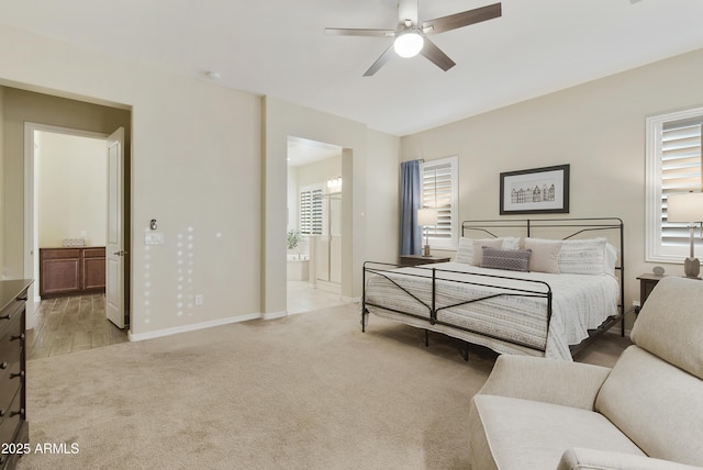 bedroom featuring ensuite bath, multiple windows, baseboards, and light colored carpet