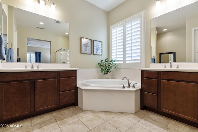 bathroom with a stall shower, a garden tub, a sink, and tile patterned floors