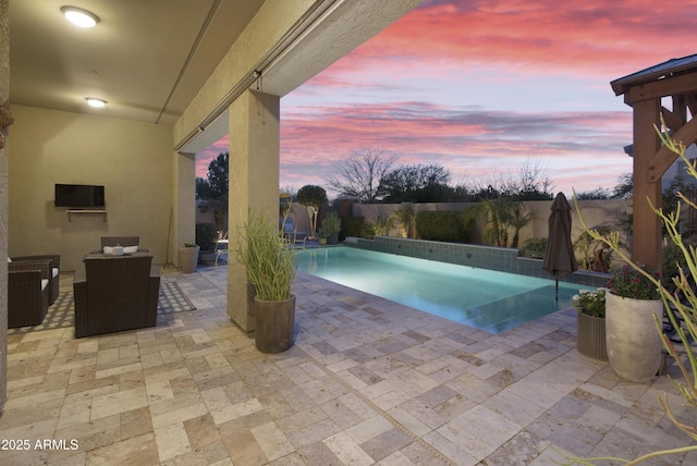 pool at dusk featuring a patio area, a fenced backyard, and a fenced in pool