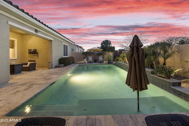 pool at dusk featuring a patio area, a fenced backyard, a fenced in pool, and a wall mounted air conditioner