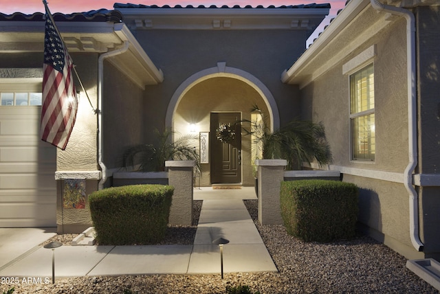 doorway to property featuring stucco siding