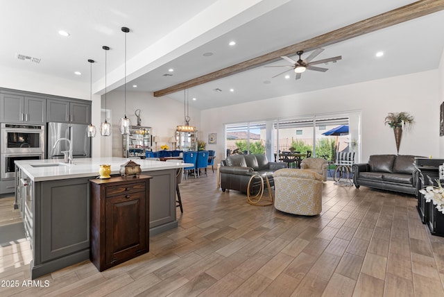 17385 W Sugar Hill Ct, Surprise, AZ 85388 - kitchen with open floor plan, light countertops, stainless steel appliances, a sink, and a ceiling fan