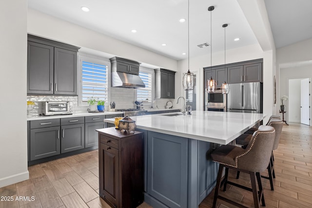 17385 W Sugar Hill Ct, Surprise, AZ 85388 - kitchen with a sink, decorative backsplash, appliances with stainless steel finishes, a large island with sink, and recessed lighting