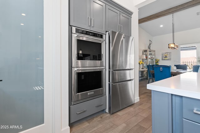 17385 W Sugar Hill Ct, Surprise, AZ 85388 - kitchen with appliances with stainless steel finishes, light wood-type flooring, gray cabinets, light countertops, and decorative light fixtures