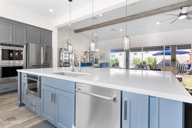 17385 W Sugar Hill Ct, Surprise, AZ 85388 - kitchen with stainless steel appliances, a sink, beamed ceiling, light countertops, and recessed lighting