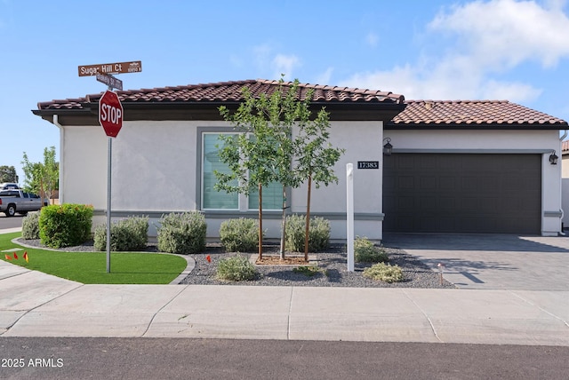 17385 W Sugar Hill Ct, Surprise, AZ 85388 - mediterranean / spanish house featuring a garage, driveway, a tiled roof, and stucco siding