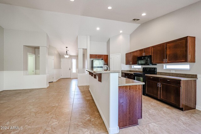 kitchen with light stone countertops, black appliances, an island with sink, hanging light fixtures, and high vaulted ceiling