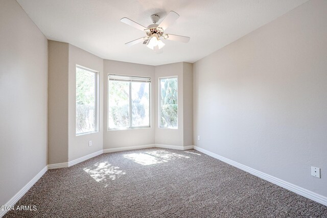 carpeted spare room featuring ceiling fan