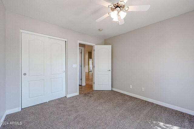 unfurnished bedroom with a closet, ceiling fan, and carpet