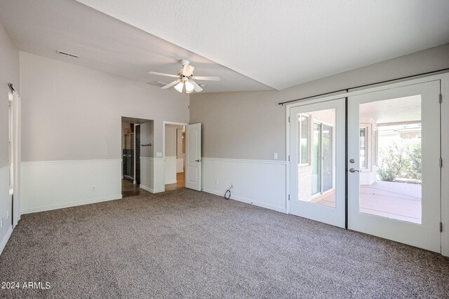 carpeted spare room with vaulted ceiling, french doors, and ceiling fan