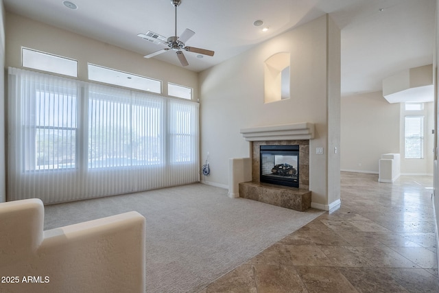 carpeted living room featuring visible vents, a ceiling fan, baseboards, and a fireplace