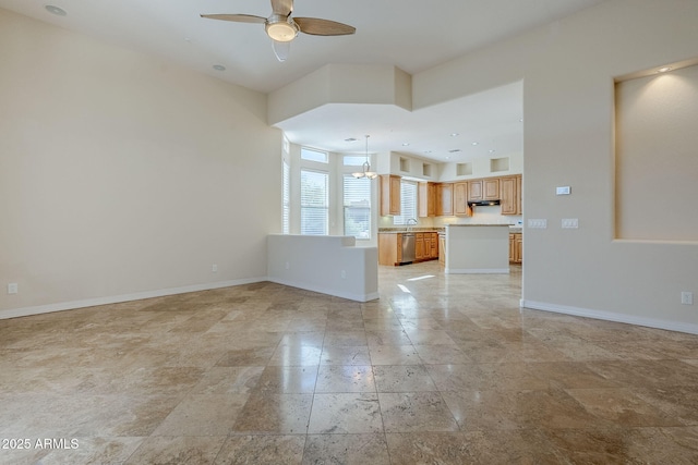 unfurnished living room featuring baseboards, ceiling fan with notable chandelier, and stone tile flooring