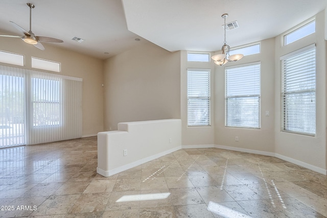unfurnished room with baseboards, visible vents, ceiling fan with notable chandelier, and stone tile flooring
