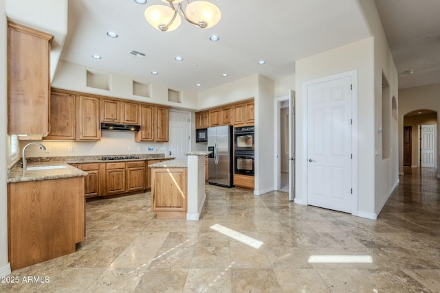 kitchen featuring arched walkways, a sink, baseboards, black appliances, and under cabinet range hood