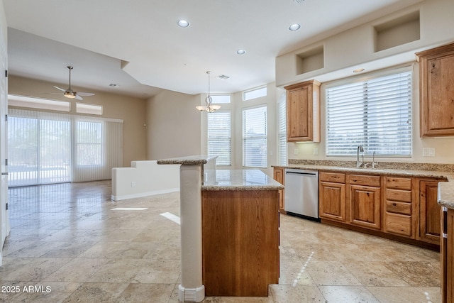 kitchen featuring stainless steel dishwasher, stone tile flooring, ceiling fan, a center island, and light stone counters
