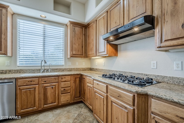 kitchen with brown cabinets, dishwasher, a sink, black gas stovetop, and under cabinet range hood