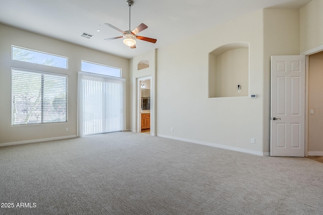 unfurnished room with baseboards, ceiling fan, light colored carpet, and visible vents
