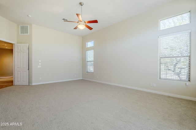 spare room with visible vents, baseboards, ceiling fan, and light colored carpet