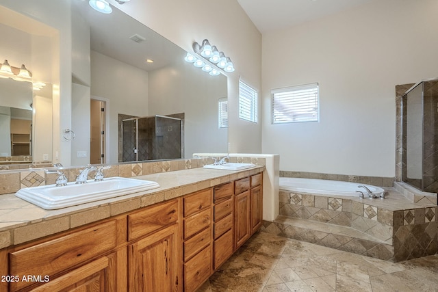 full bathroom featuring double vanity, stone finish floor, a bath, a stall shower, and a sink