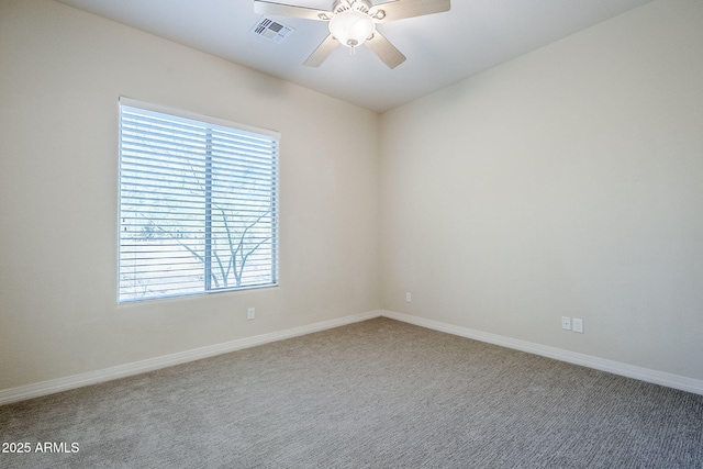 carpeted empty room featuring a ceiling fan, baseboards, visible vents, and plenty of natural light