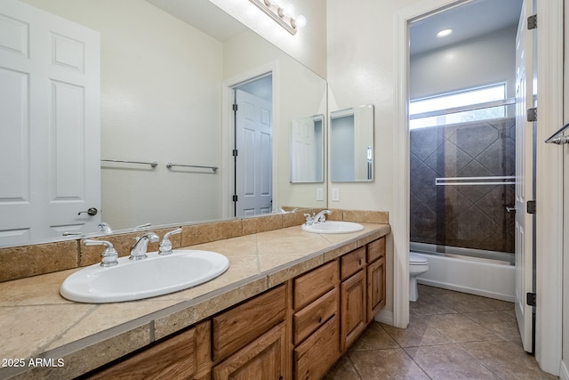 bathroom with a sink, combined bath / shower with glass door, toilet, and double vanity