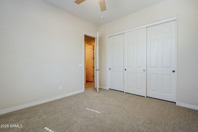 unfurnished bedroom with baseboards, carpet flooring, a ceiling fan, and a closet
