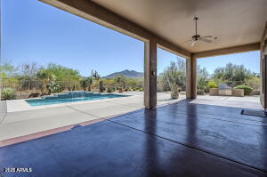 view of patio / terrace featuring a mountain view, a ceiling fan, and an outdoor pool