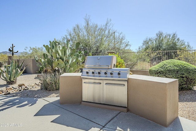 view of patio featuring area for grilling, an outdoor kitchen, and fence