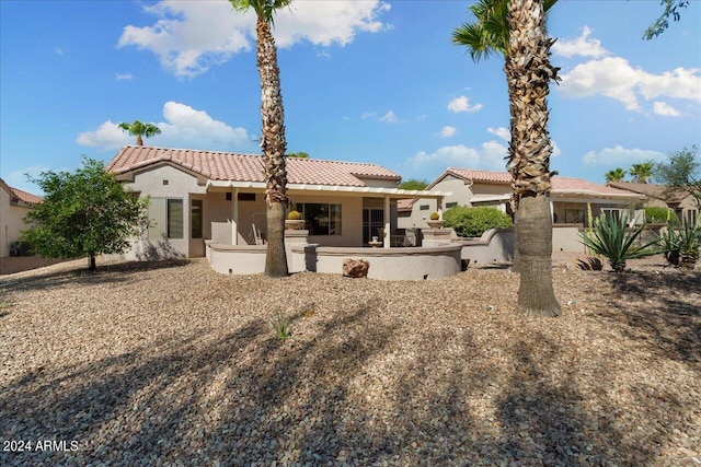 rear view of property featuring an outdoor kitchen and a patio area